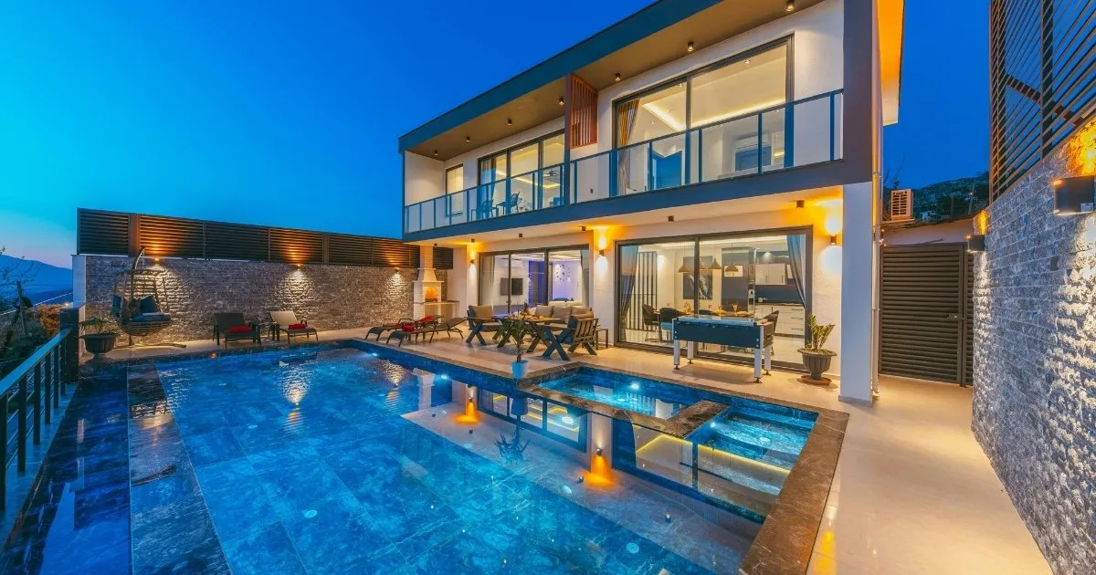 Luxury villa in Goa at night with illuminated swimming pool and outdoor seating